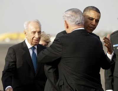 President Barack Obama hugs Israeli Prime Minister Benjamin Netanyahu, as Israeli President Shimon Peres looks on at left, before his departure Friday. (Associated Press)