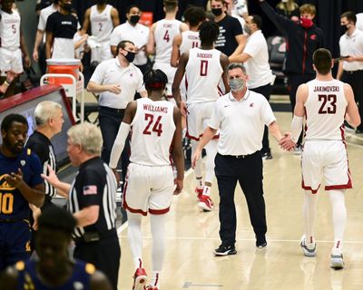 Washington State coach Kyle Smith greets forward Andrej Jakimovski (23) and guard Noah Williams (24) during a Pac-12 game in February against Cal in Pullman.  (Associated Press)
