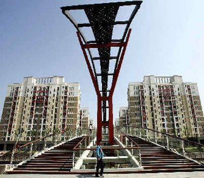 
A man walks past newly built apartment complexes in Shanghai. China's efforts to slow its steamrolling economy are being foiled by massive construction of luxury housing projects, shopping malls, showcase government buildings and factories. 
 (Associated Press / The Spokesman-Review)