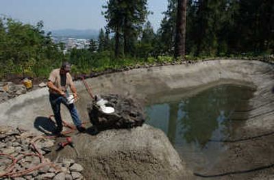 
Ken Brangwin of A.M. Landshaper works to seal a crack in a pond in the Moore-Turner Heritage Gardens earlier this month. 
 (KATE CLARK / The Spokesman-Review)