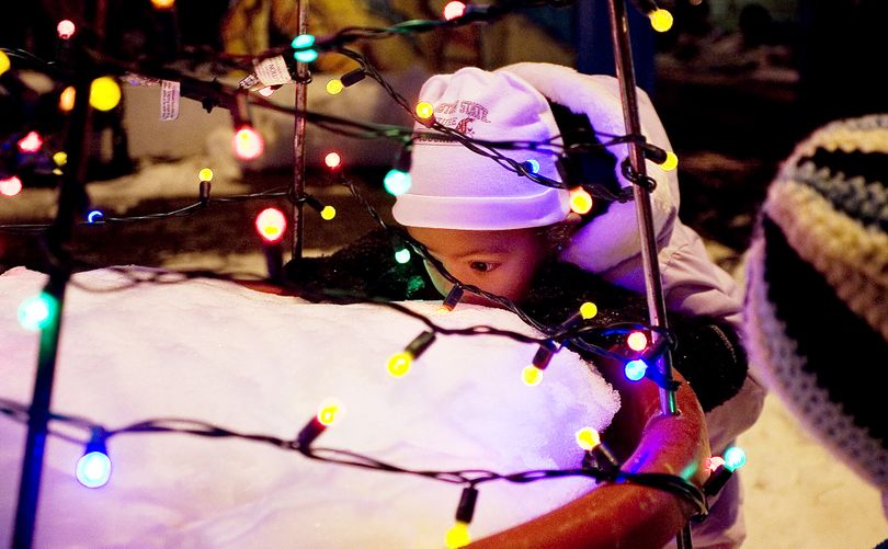 Prisca Sakwa, 16 months, of Pullman, Wash., licks snow from a Pine Street Plaza planter during the Pullman Holiday Festival and Tree Lighting ceremony Friday, Dec. 3, 2010. (Dean Hare / Moscow-pullman Daily News)