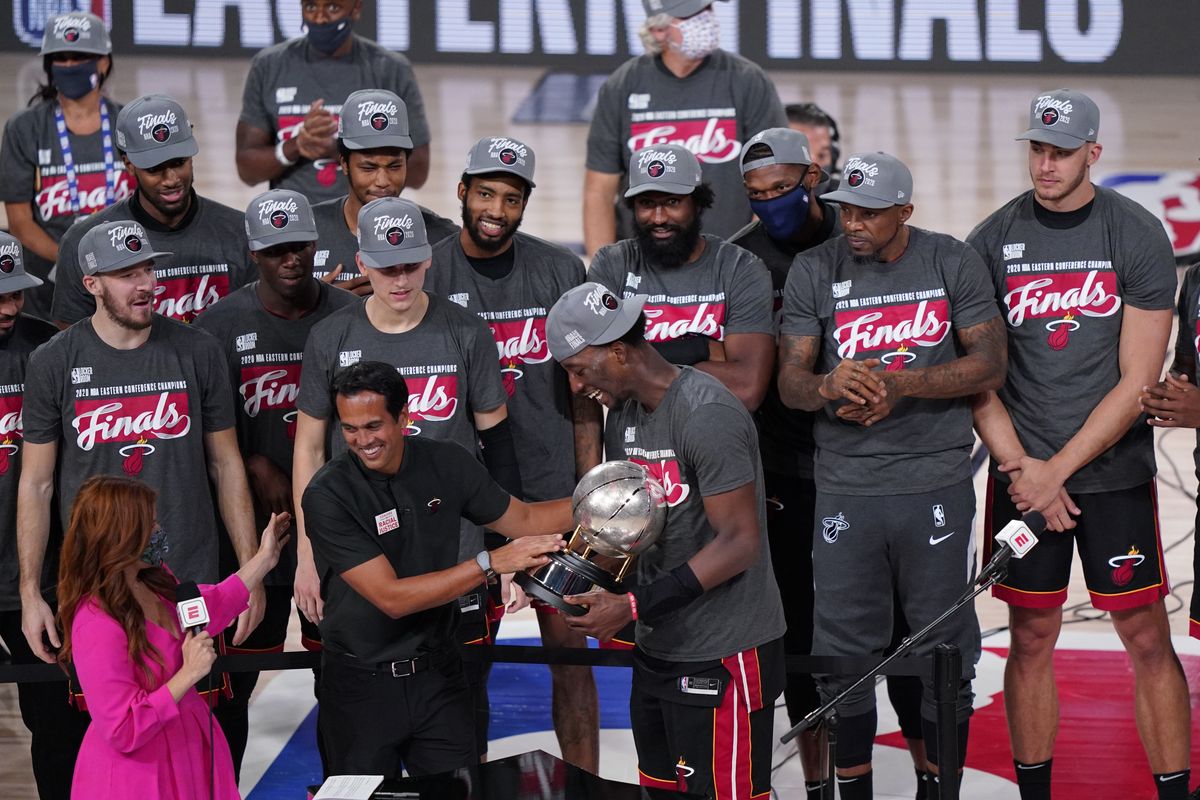 Miami Heat head coach Erik Spoelstra, center left, hands the Eastern Conference trophy to Bam Adebayo (13) as they celebrate their NBA conference final playoff basketball game win over the Boston Celtics with the Eastern Final trophy Sunday, Sept. 27, 2020, in Lake Buena Vista, Fla.  (Mark J. Terrill)