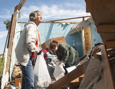 Stephanie Fatheree, right, salvages items from her house damaged from the tornado the previous night with help from a neighbor on Thursday, April 9, 2020, in Harrisburg, Ark. Fatheree said she took shelter with her mother, Angie, in the bathroom during the tornado. Severe storms with high winds, hail and possible tornadoes have caused damage to dozens of homes and businesses in parts of Indiana and Arkansas. (Quentin Winstine / AP)