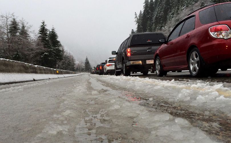 Vehicles along eastbound Interstate 90 heading up Snoqualmie Pass are stopped in snow and slush during a road closure last winter. (Ted S. Warren / Associated Press file)