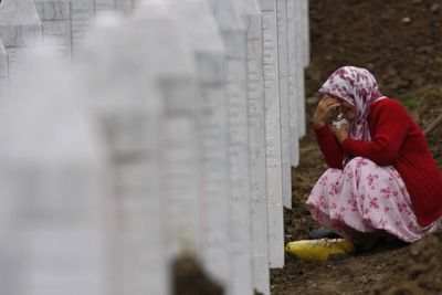 A Bosnian Muslim woman weeps beside the gravestone of her relative  during a funeral ceremony Saturday  near Srebrenica,  northeast of Sarajevo.   (Associated Press / The Spokesman-Review)