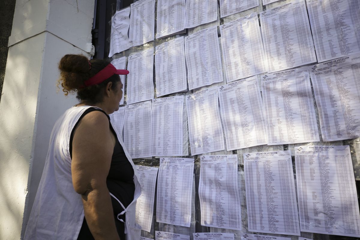 A woman checks his ID number outside a voting center during general elections in Managua, Nicaragua, Sunday, Nov. 7, 2021. Nicaraguan President Daniel Ortega seeks a fourth consecutive term against a field of little-known candidates while those who could have given him a real challenge sit in jail.  (Andres Nunes)