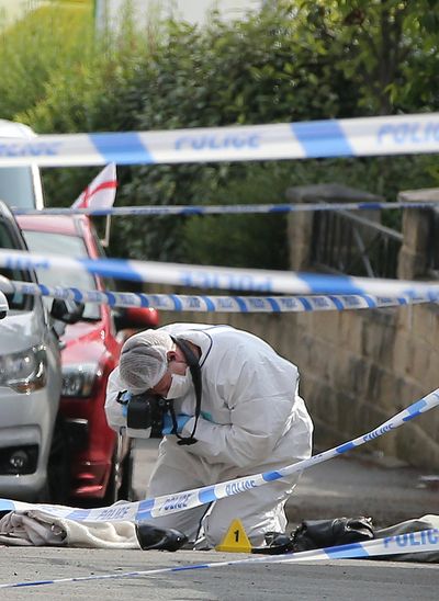 A forensics officer takes photos of a female shoe, at the scene after Labour MP Jo Cox was left in a critical condition following being shot and stabbed in an attack in her constituency, in Birstall, West Yorkshire, England, Thursday, June 16, 2016. Police say British lawmaker Jo Cox has died after being shot in the town of Birstall, part of the area she represented. (Nigel Roddis / Associated Press)