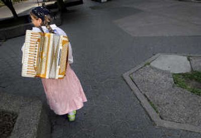 
Lilian Deck, 12, carries her accordion along Spokane Falls Boulevard on  Monday. She is playing for pedestrians to raise funds to travel to Washington, D.C., next month for the Coupe Mondiale accordion competition. Deck is one of three Spokane musicians who need  travel money.  
 (Brian Plonka / The Spokesman-Review)