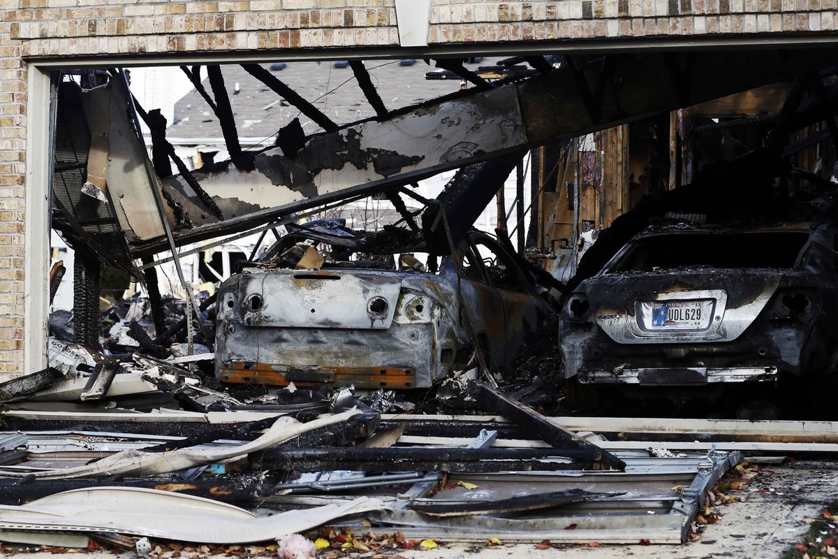 Two cars sit in a home that was heavily damaged by a explosion, Sunday, Nov. 11, 2012, in Indianapolis. Nearly three dozen homes were damaged or destroyed, and seven people were taken to a hospital with injuries, authorities said Sunday. The powerful nighttime blast shattered windows, crumpled walls and could be felt at least three miles away. (Darron Cummings / Associated Press)