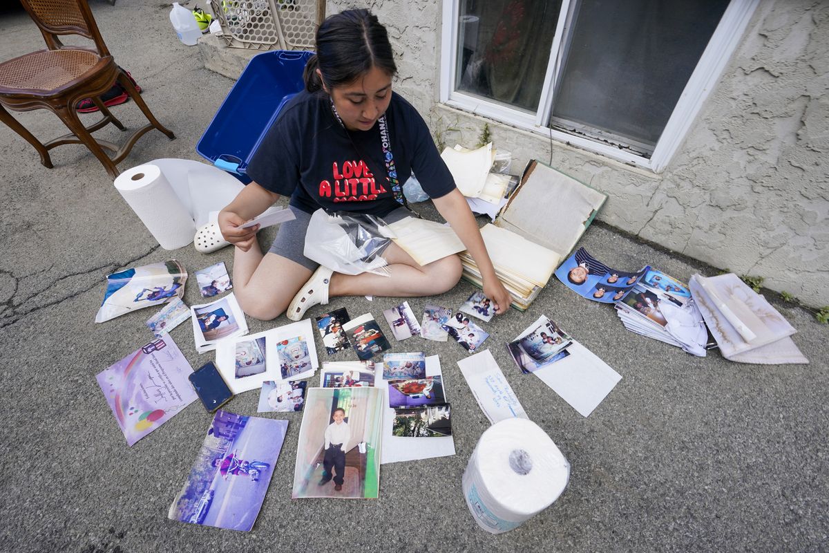 Nelis Gramao dries out her family's photo album while cleaning out her flood damaged home, Friday, Sept. 3, 2021, in Mamaroneck, N.Y. More than three days after the hurricane blew ashore in Louisiana, Ida's rainy remains hit the Northeast with stunning fury on Wednesday and Thursday, submerging cars, swamping subway stations and basement apartments and drowning scores of people in five states.  (Mary Altaffer)