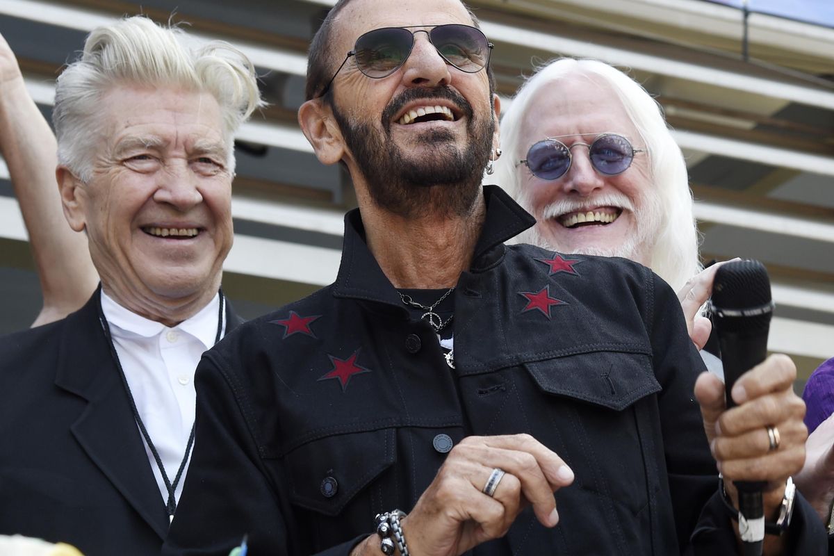 In this Friday, July 7, 2017, file photo, Ringo Starr, center, is joined by guests including filmmaker David Lynch, left, and musician Edgar Winter, second from right, during a 77th birthday celebration for Starr outside Capitol Records, in Los Angeles. Starr is among the list of celebrated people designated to receive British knighthoods. (Chris Pizzello / Chris Pizzello/Invision/AP)