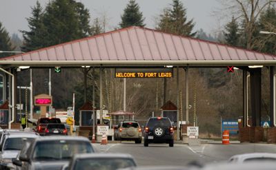 Vehicles enter a gate of the U.S. Army base at Fort Lewis, Wash., on Tuesday. A 16-year-old girl was found dead and another girl discovered unconscious in a barracks on the base.  (Associated Press / The Spokesman-Review)