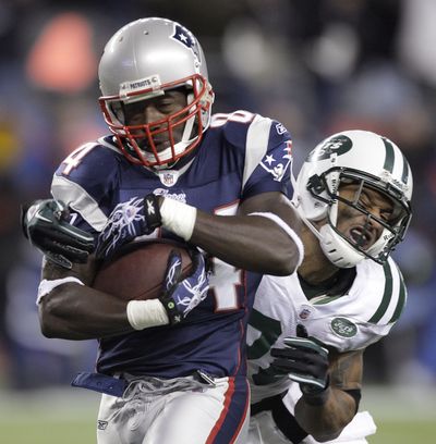 New England’s Deion Branch lugs the ball and Dwight Lowery into the end zone. (Associated Press)