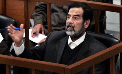 
Former Iraqi President Saddam Hussein speaks to Head Judge Raouf Abdel Rahman as his trial resumes in Baghdad on Tuesday. 
 (Associated Press / The Spokesman-Review)