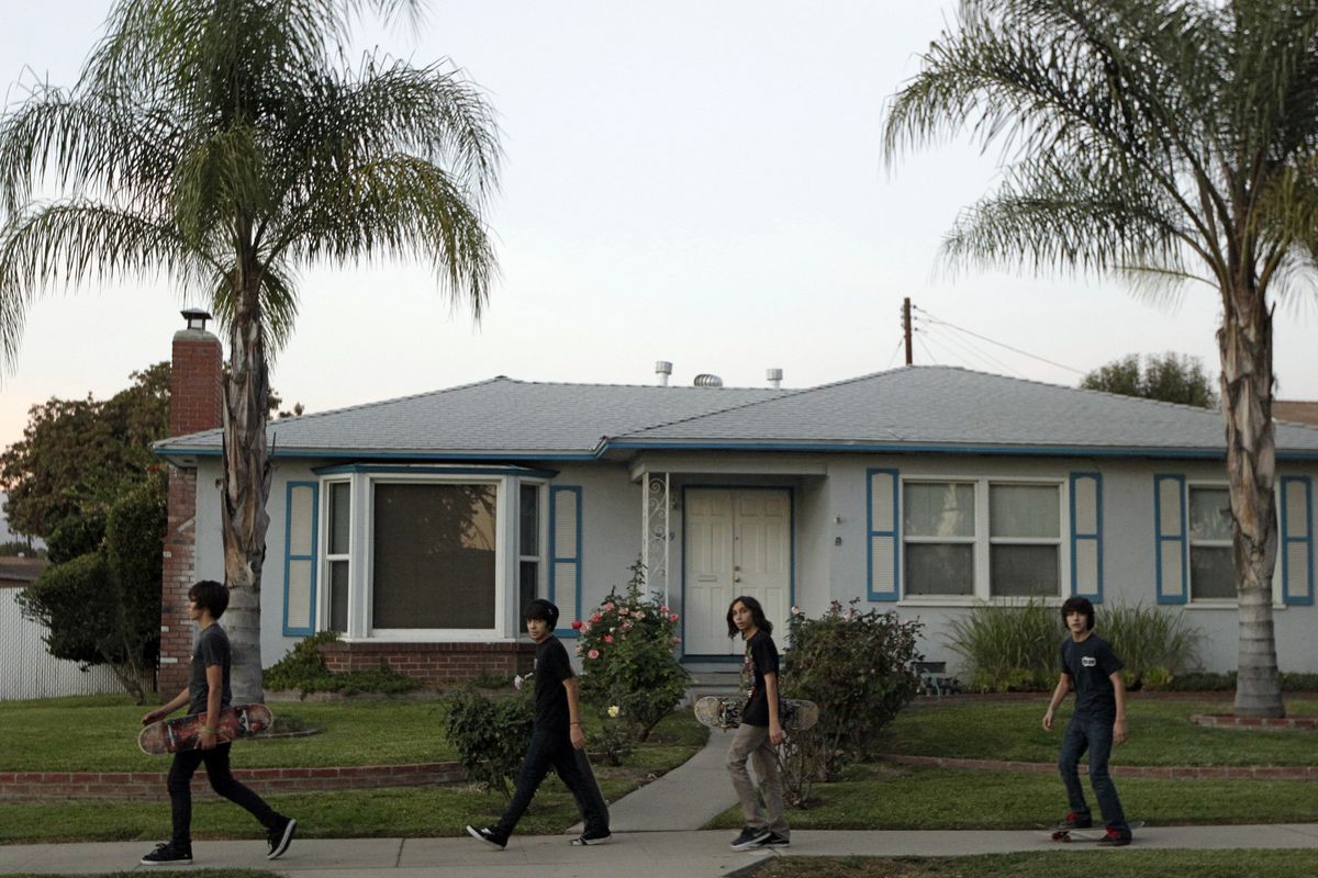 Unidentified teens walk past the home of the family of Arifeen David Gojali in Pomona, Calif., on Tuesday, Nov. 20, 2012. Three California men excited at the prospect of training in Afghanistan to become terrorists prepared, authorities say, by simulating combat with paint ball rifles, wiping their Facebook profiles of any Islamic references and concocting cover stories. Family members told The Associated Press they were shocked by Gojali