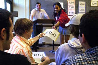 
Laura Ditt, 20, hands John Harris, 20, the prize value of a correct answer for team, the Ramrods, during Engineering Jeopardy on Thursday at Gonzaga University.
 (Jed Conklin / The Spokesman-Review)