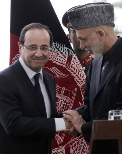Afghan President Hamid Karzai, right, shakes hands with French President Francois Hollande after their joint press conference in Kabul, Afghanistan, on Friday. (Associated Press)