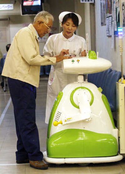A nurse shows a man how to use a robot to test his veins and blood flow at a hospital in Aizu Wakamatsu, Japan. Associated Press
(Associated Press / The Spokesman-Review)