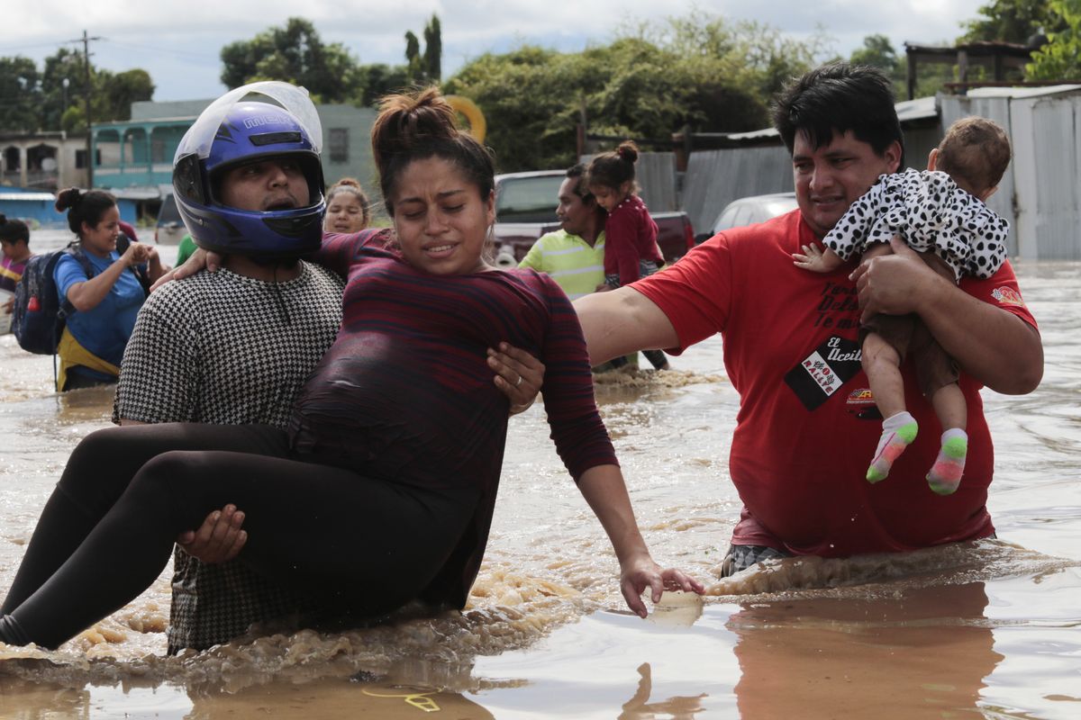 A pregnant woman is carried out of an area flooded by water brought by Hurricane Eta in Planeta, Honduras, Thursday, Nov. 5, 2020. The storm that hit Nicaragua as a Category 4 hurricane on Tuesday had become more of a vast tropical rainstorm, but it was advancing so slowly and dumping so much rain that much of Central America remained on high alert.  (Delmer Martinez/Associated Press)