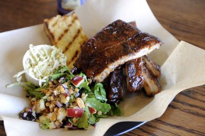 This platter from Lazy Bones Barbecue holds a pound of barbecue ribs, an apple-lentil salad, a scoop of vinegar coleslaw and a slab of grilled bread. (Jesse Tinsley / The Spokesman-Review)