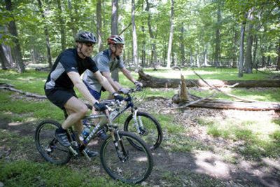 
Prime Minister Anders Fogh Rasmussen of Denmark, left, and President Bush navigate a path on mountain bikes at Camp David, Md., on Friday. The president is an avid mountain biker. 
 (Associated Press / The Spokesman-Review)