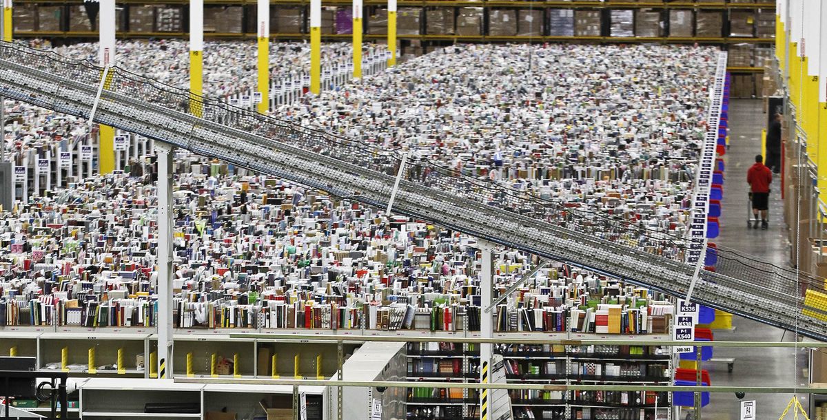 An employee walks a wide isle at Amazon.com’s fulfillment center in Phoenix. Millions of Internet shoppers were expected to click on items Monday as retailers revved up deals to grab online holiday shopping dollars on the first working day after the busy holiday weekend. (Associated Press)