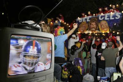 
Paradegoers watch Super Bowl XLII during the Krewe of Bacchus parade in New Orleans on Sunday. Associated Press
 (Associated Press / The Spokesman-Review)