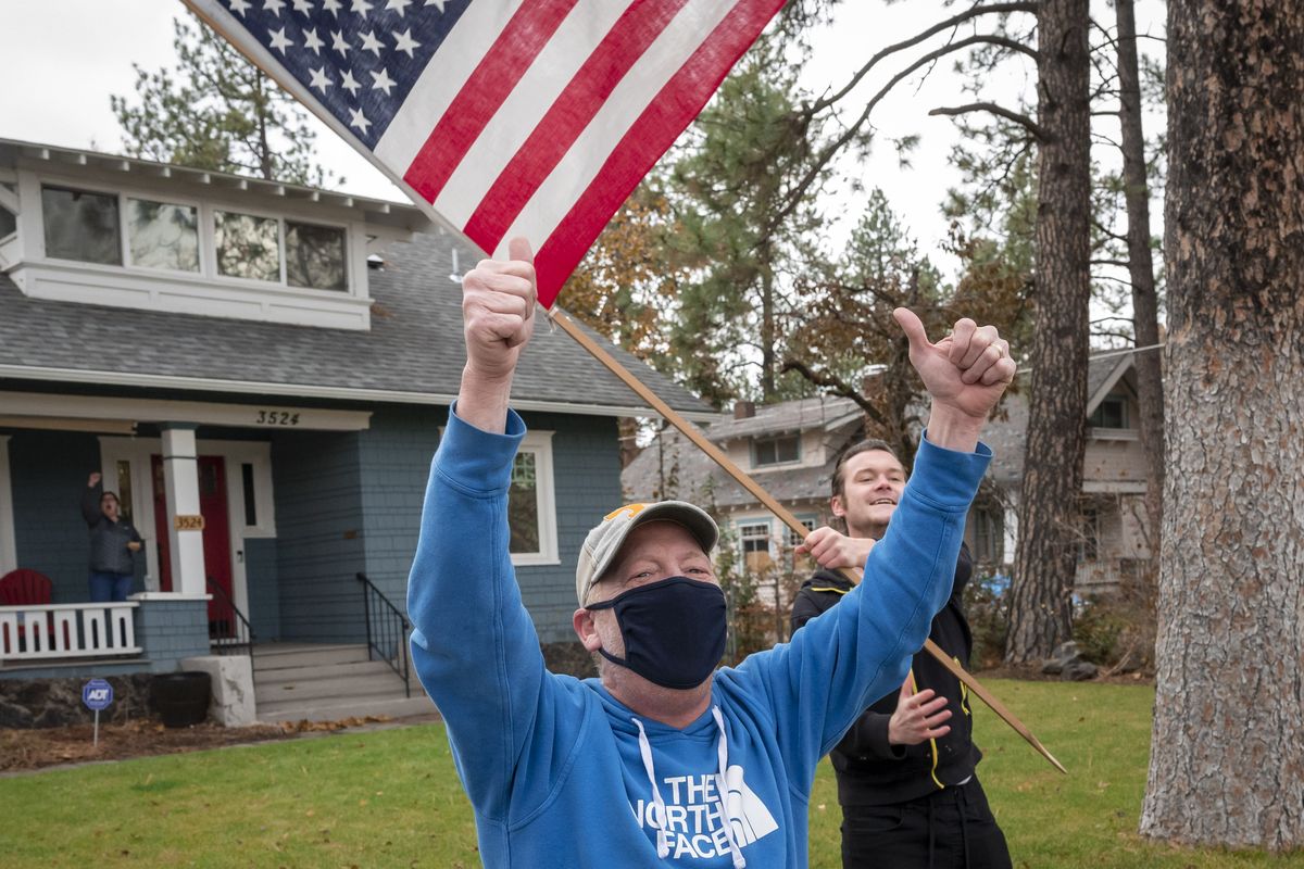Todd Wear, left, and Dalin Tipton, celebrate President-elect Joe Biden and Vice President-elect Kamala Harris’s win as they wave to passing cars on South Grand Boulevard, Saturday, Nov. 7, 2020.  (Colin Mulvany/THE SPOKESMAN-REVIEW)