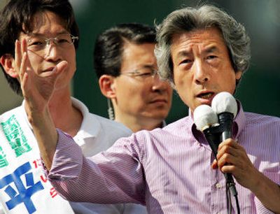 
Japan's Prime Minister Junichiro Koizumi, right, speaks to the crowd as his party candidate Masaaki Taira, left, listens, during a campaign stop for his ruling Liberal Democratic Party in Tokyo Saturday. 
 (Associated Press / The Spokesman-Review)