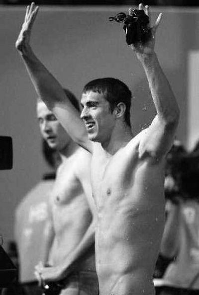 USA's Michael Phelps waves to the crowd after winning 100-meter butterfly. Teammate Ian Crocker, left, later caused a relay team to be disqualified, preventing Phelps from winning his eighth gold medal.
(Associated Press / The Spokesman-Review)