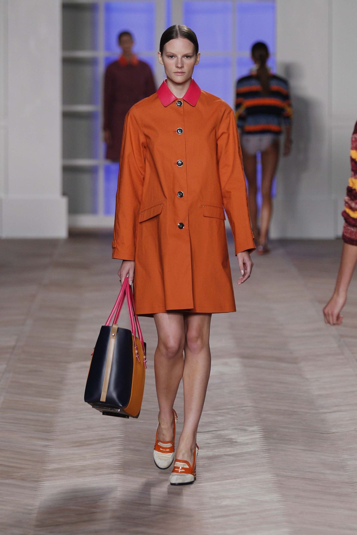 A model wearing a design from the Tommy Hilfiger Spring 2012 women’s collection strolls the catwalk during Fashion Week in New York in September. Pantone has chosen a reddish-orange hue as their top color of the year for 2012. (Associated Press)