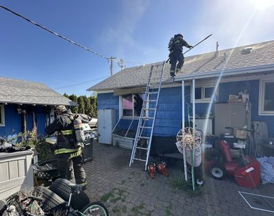 Firefighters extinguish a fire inside a bedroom of a home Thursday morning at 7417 N. Crestline St. in Spokane. One man was taken to the hospital in serious condition for smoke inhalation. (Courtesy of Spokane Fire Department)