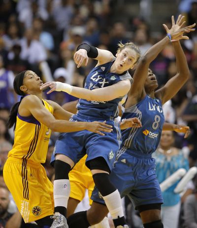 Minnesota Lynx’s Lindsay Whalen, center, looks at a loose ball as she is defended by Los Angeles Sparks’ Candace Parker, left. (Associated Press)