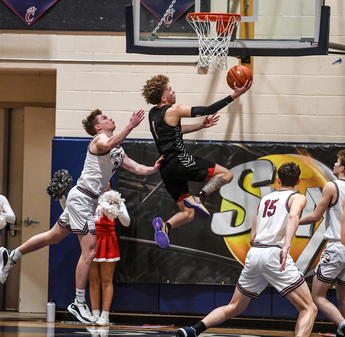 Ferris guard Trayce Atkins flies to the basket past Mt. Spokane forward Ben Ehlert, left, Friday,Jan. 21, 2022 at MSHS.guard  (Dan Pelle/THE SPOKESMAN-REVIEW)
