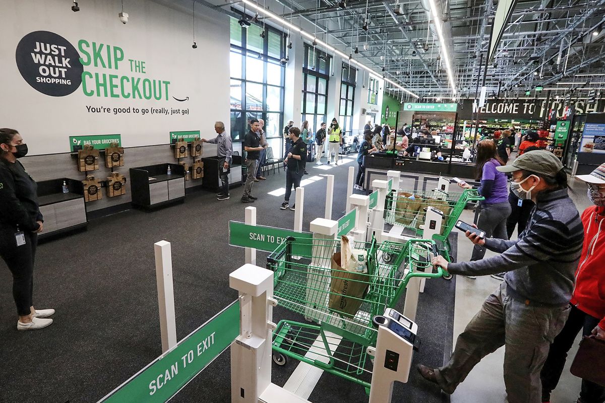 Customers using cashierless technology to checkout with an app or credit card at the first Amazon Fresh in Washington, on opening day, Thursday, June 17, 2021 in Bellevue, Washington. The store also has cashiers.  (Ken Lambert/Seattle Times/TNS)