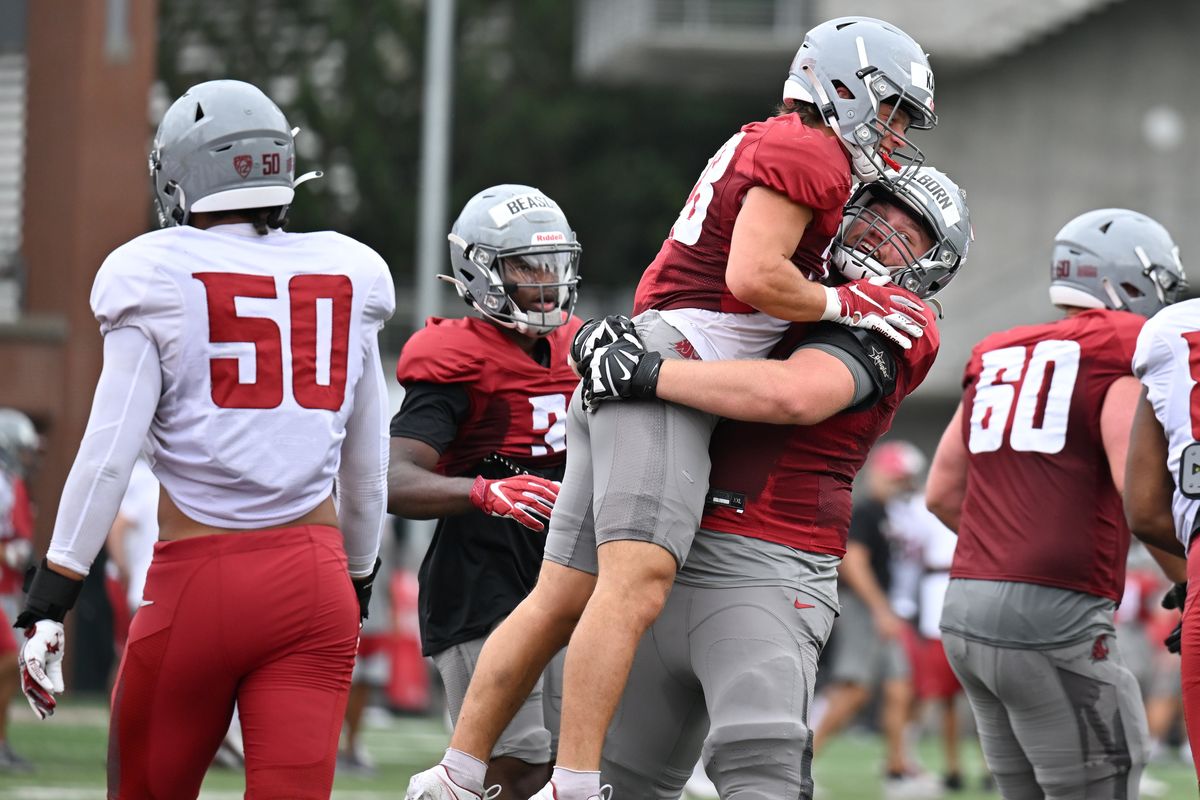 Washington State guard Christian Hilborn hoists running back Kannon Katzer after Katzer ran for a touchdown during practice Aug. 9 at Rogers Field in Pullman.  (Tyler Tjomsland/The Spokesman-Review)