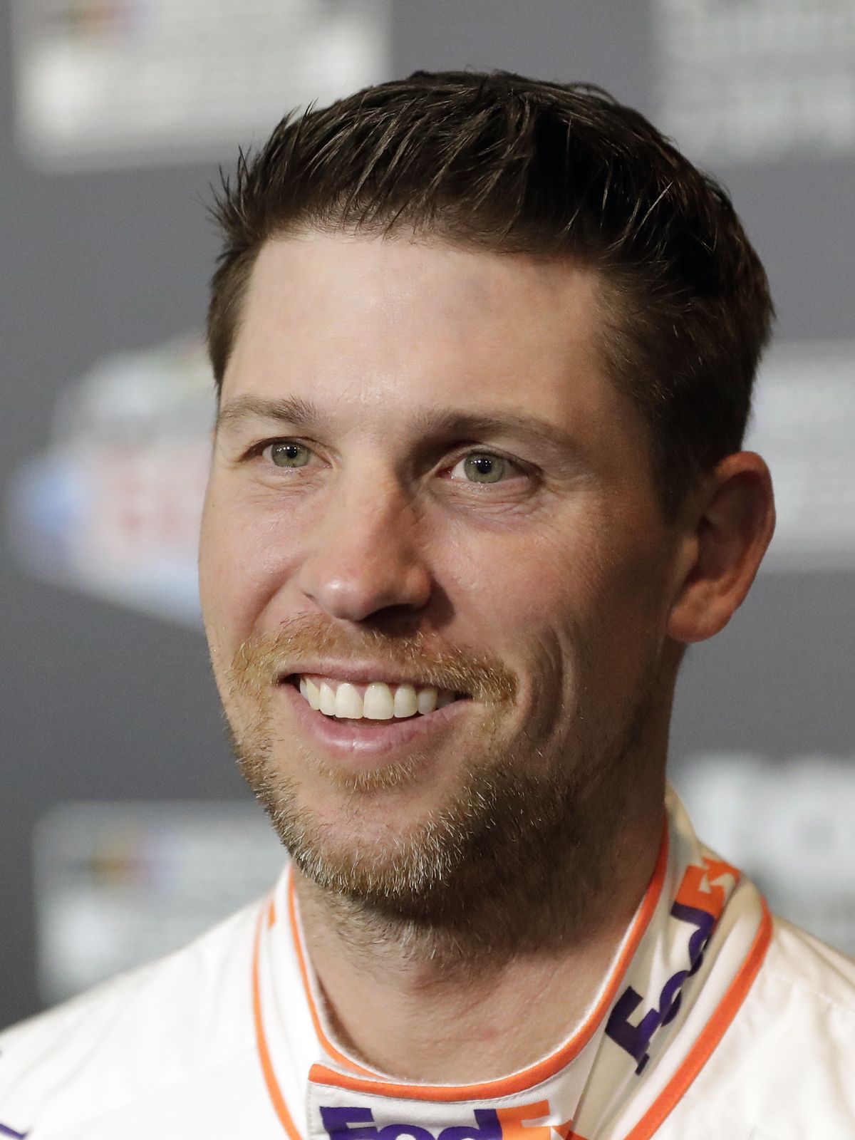 Denny Hamlin smiles during NASCAR Daytona 500 auto racing media day at Daytona International Speedway, Wednesday, Feb. 12, 2020, in Daytona Beach, Fla. Picking the car number for Michael Jordan's new NASCAR team was a slam dunk: Bubba Wallace will drive the No. 23 car when the team makes its debut next season. Jordan and Hamlin announced last month they had formed a NASCAR team with Bubba Wallace as the driver.  (Associated Press)