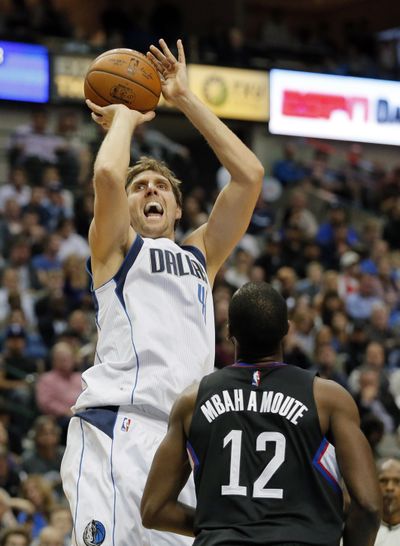 Dallas Mavericks forward Dirk Nowitzki, left, attempts a shot of Los Angeles Clippers' Luc Mbah a Moute in the second half of an NBA basketball game, Wednesday, Nov. 23, 2016, in Dallas. Nowitzki will be out at least two more games with a right Achilles tendon injury. (Tony Gutierrez / Associated Press)