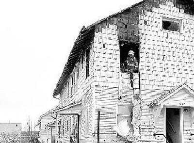 
Spokane firefighters finish mopping up a fire at 506 W. Sinto Ave. Police are looking for Charles Dawkins, who's accused of starting the fire.  A Red Cross volunteer said at least nine people were displaced due to the alleged arson. 
 (Dan Pelle / The Spokesman-Review)