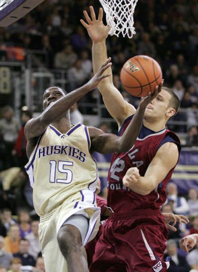 
Washington's Bobby Jones drives to the basket with Loyola Marymount's Dustin Brown defending during the first half in Seattle. The Huskies beat the Lions 112-65 on Friday and await a date with Gonzaga on Dec. 4.
 (Associated Press / The Spokesman-Review)