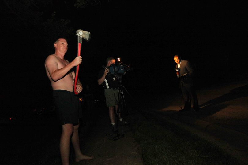 An axe wielding neighbor threatens Philadelphia reporter, Kenneth Moton with ABC news as he reports in front of the home of a 17-year-old Concord High school student who Congressman Anthony Weiner made contact with through Twitter Friday June 10, 2011 in Wilmington Delaware. (The Pederson / The News Journal)