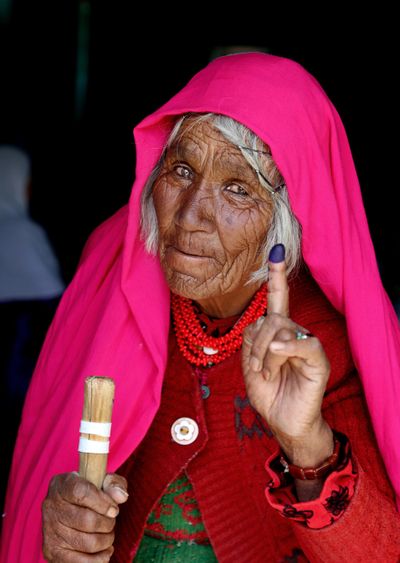 An Afghan woman shows her inked finger after casting her vote at a polling station in Bamiyan, Afghanistan, Saturday. (Associated Press)