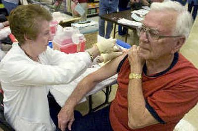 
Maureen Jaeger, a registered nurse with Maxim Health Care, gives a flu shot to Stan Jansen at the Rosauers supermarket on Francis Avenue on Tuesday. 
 (Colin Mulvany / The Spokesman-Review)