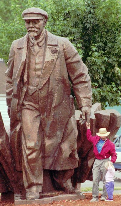 Terry Fox and his niece Diane Fox-Hindley, 3, visit  the bronze statue of former Soviet leader Vladimir Lenin Monday, June 5, 1995, in the Fremont neighborhood of Seattle. (Robert Sorbo / Associated Press)