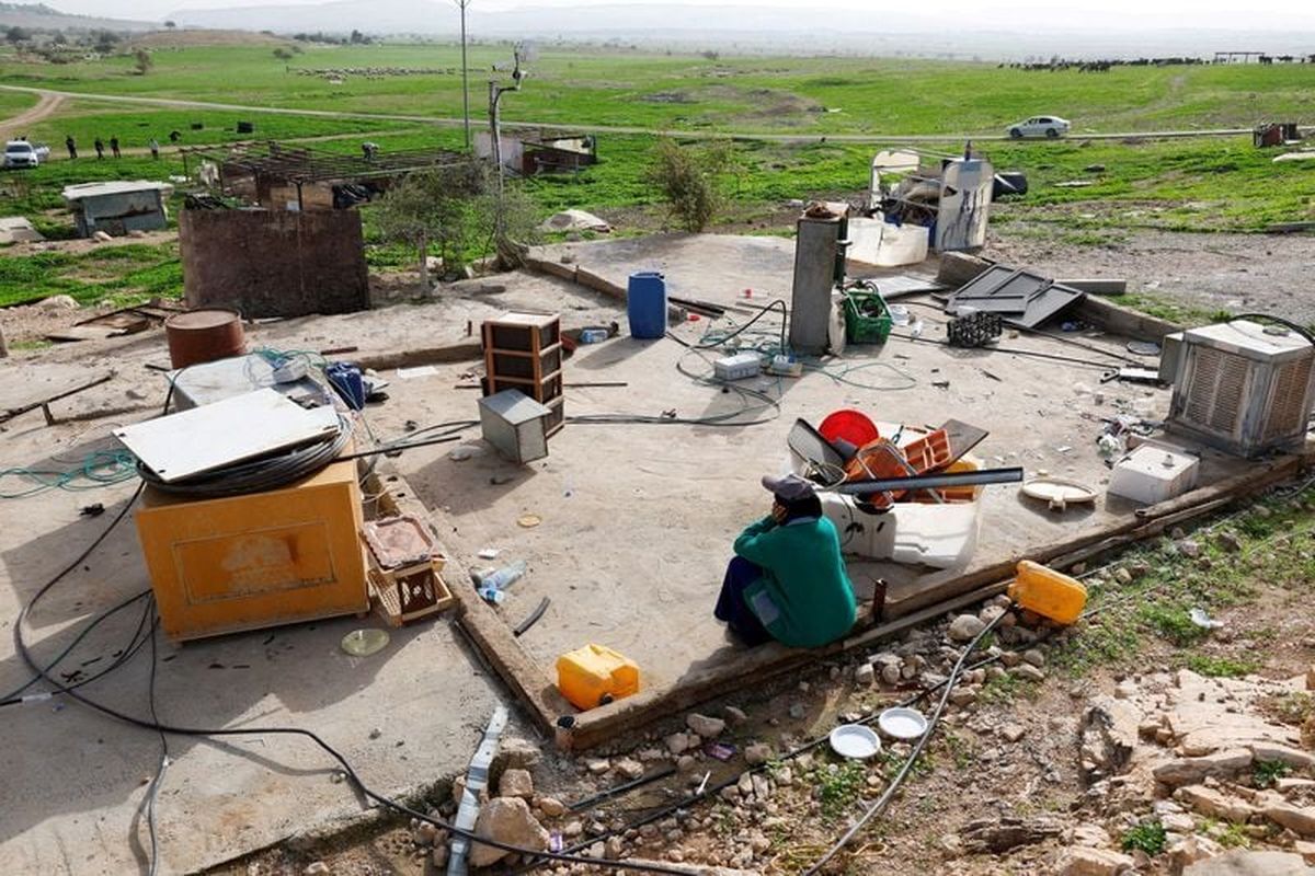 A Palestinian woman sits as members of a Palestinian Bedouin community leave following Israeli settler violence, on Jan. 24, in Ein al-Auja near Jericho, in the Israeli-occupied West Bank. (Reuters )