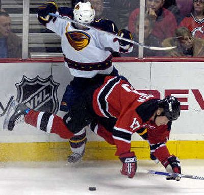 
Atlanta's Garnet Exelby, left, checks New Jersey's Erik Rasmussen. 
 (Associated Press / The Spokesman-Review)
