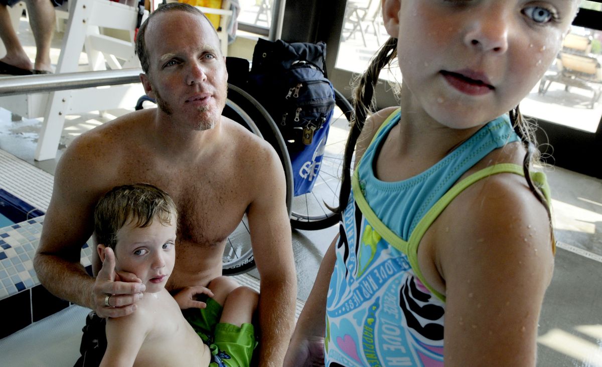 Sean Halsted, of Rathdrum, here with his 5-year-old twins, Ethan and Rileigh,  started training for the Paralympics after a helicopter training accident in 1998 caused him to lose most of the use of his legs.  (Kathy Plonka / The Spokesman-Review)
