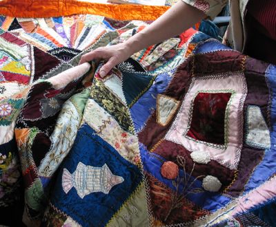An appraiser examines a vintage quilt at the MAC Appraisal Days event in Spokane. (Cheryl-Anne Millsap / Photo by Cheryl-Anne Millsap)