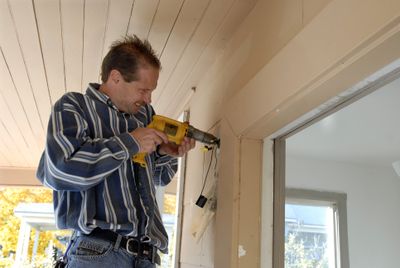 John Jones installs new porch lights at 2008 W. Sharp Ave. in the West Central neighborhood in Spokane recently.  The Off-Broadway Family Outreach ministry is renovating the  100-year-old home, which  has fallen into disrepair. The home will be used as an emergency shelter for women and children.  (J. Bart Rayniak / The Spokesman-Review)