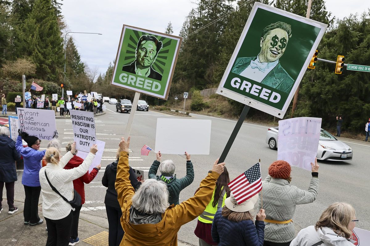 Protesters wave to passing traffic during the fifth Wednesday weekly anti-Elon Musk protest by Indivisible Valley outside the offices of Musk’s Starlink and SpaceX on March 19 in Redmond, Washington. (Kevin Clark/The Seattle Times/TNS)